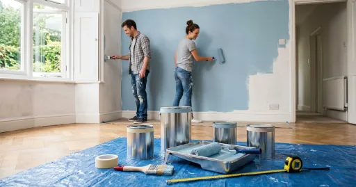 Un couple qui peint une pièce de la maison avec des pot de peinture qu'ils viennent d'acheter